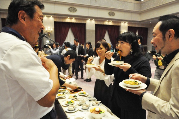 【写真を見る】各店のこだわりを聞きがら試食する審査員たち