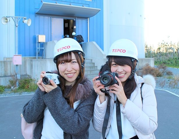 東京電力フュエル＆パワー 川崎火力発電所の煙突の前で撮影するカメラガールズ