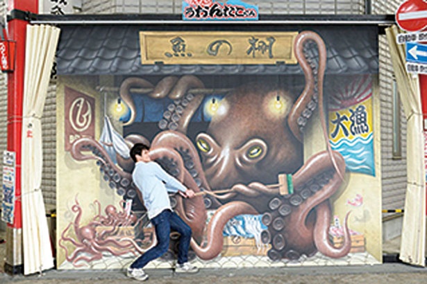 【写真を見る】巨大なタコとデッキブラシで大格闘する写真が撮れるトリックアート/明石 魚の棚