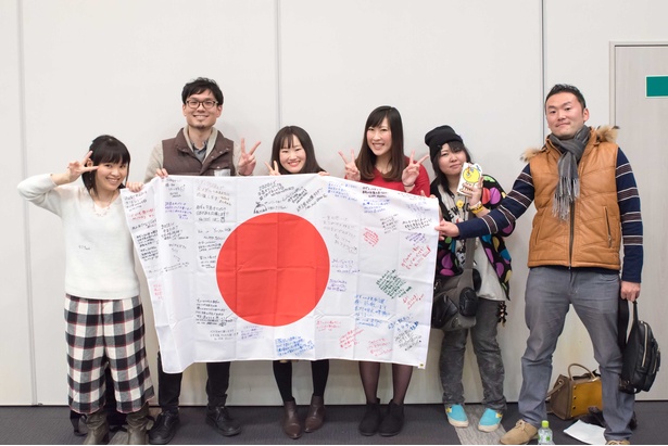 日本の国旗にたくさんのメッセージを記入