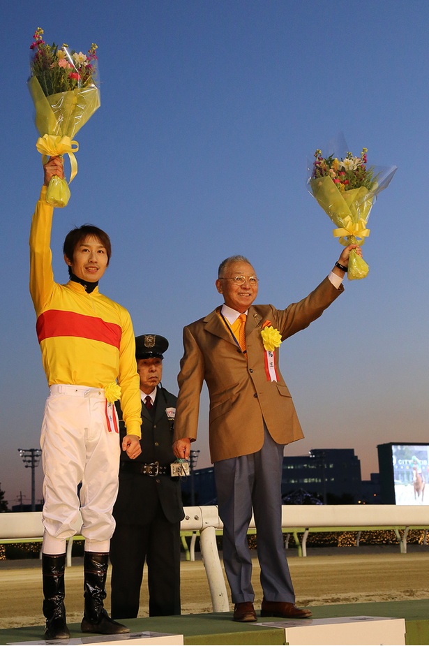 表彰式で贈呈された花束を高く掲げ、ファンの声援に応える田辺(左)とコパ(右)