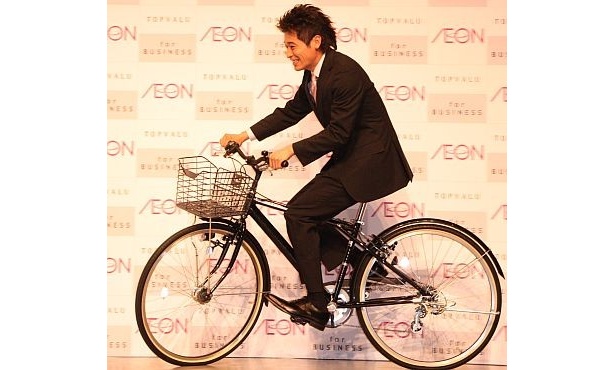会見には自転車に乗って登場！