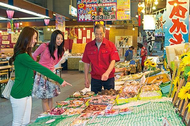 【写真を見る】鮮魚店のスタッフとの会話も市場ならではの楽しみ。魚のおいしい食べ方なども教えてくれる