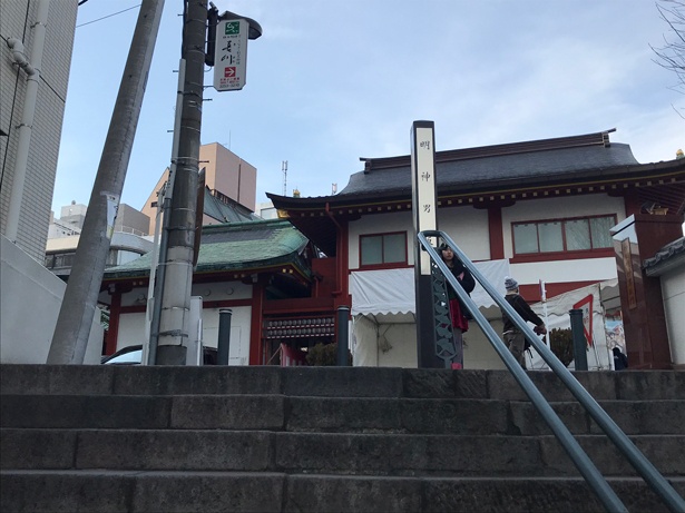 【写真を見る】神田明神の階段の踊り場から頂上を見上げたところ