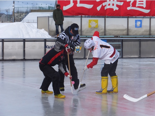 【写真を見る】スケート靴の代わりに長ぐつを履き、硬いパックの代わりにウレタンボールを打ち合い、点数を競う