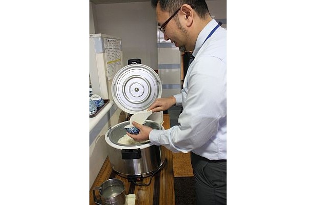 ご飯をよそう男性社員。毎日食べているからはからなくても自分の量がわかるのだそう