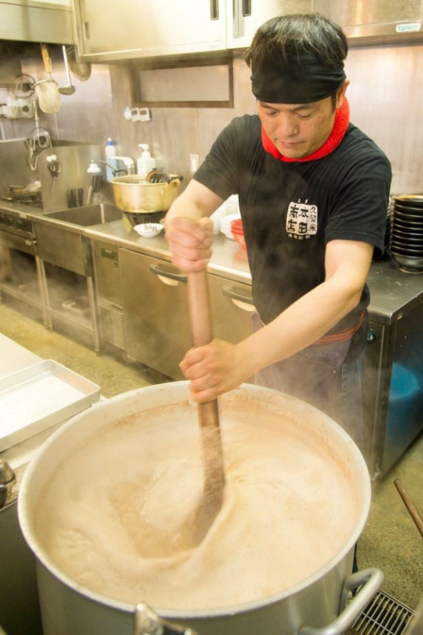 店主の本田眞一さん。寸胴を頻繁に混ぜながら豚骨を煮込んでいく。丁寧に骨の下処理をしているため臭みがない