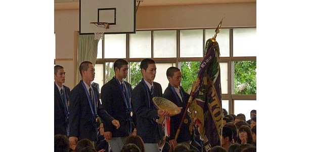 優勝旗と盾を持って入場する興南野球部員