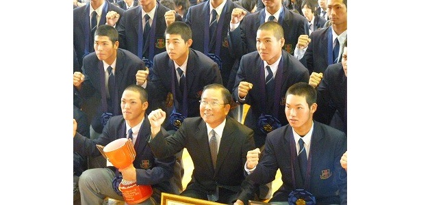 記念撮影にガッツポーズで応える笑顔の我喜屋監督
