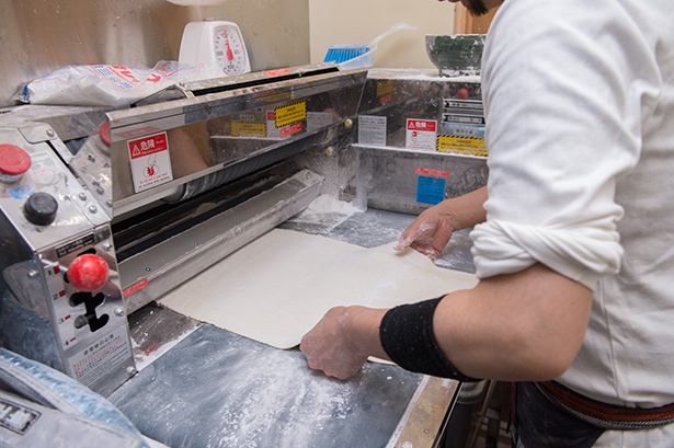 店内奥での製麺の様子。切れ端は黒砂糖で味付けをして揚げ、1袋50円の数量限定で販売している