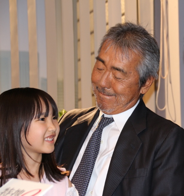 娘役の庄野凛を抱きかかえ、笑顔の寺尾聰
