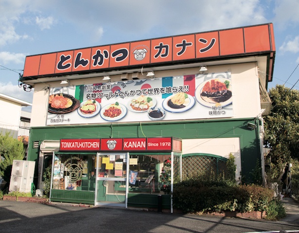 料理写真や国旗、ロゴなどが目を引く、にぎやかな外観 / とんかつキッチン カナン