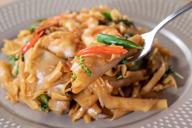 ツルツル、モチモチとした食感が楽しい平たい形状の米粉麺。現地のタイ人はフォークとスプーンの両方を使って食べる