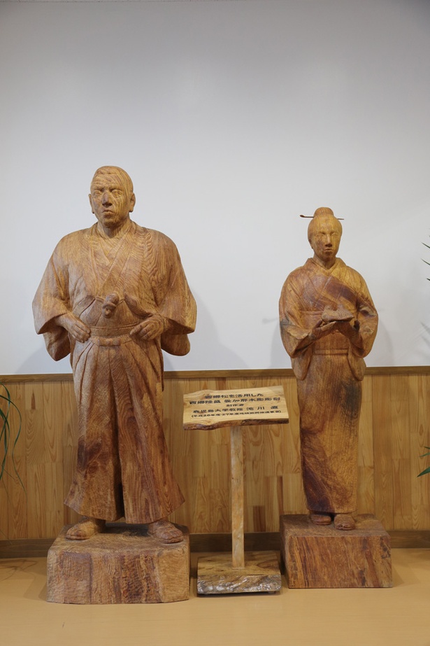 【写真を見る】龍郷町生涯学習センター りゅうがく館 / 西郷松で彫られた 西郷と愛加那が出迎え
