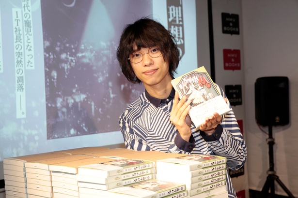 著書を手に、満足気な表情を浮かべる河邉さん