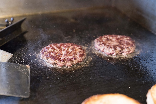 【写真を見る】肉の味と肉汁がしっかりと感じられるパテは、全体の味の要。赤身と脂肪分の割合が絶妙なパテに塩胡椒を丁寧にふって、両面をこんがりと焼く