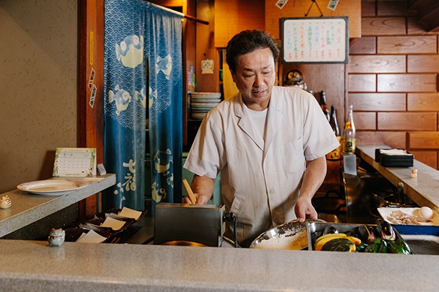 【写真を見る】ステーキ屋で働いていた髙橋さんが「天ぷらと串 髙尾」を継いで30年。「髙尾という店名は、親族の名字の『髙橋』と『尾崎』から一文字ずつ取ったんですよ(笑)」