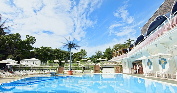 白い造りのプールサイドを囲む緑は、ホテルの名物である日本庭園の木々