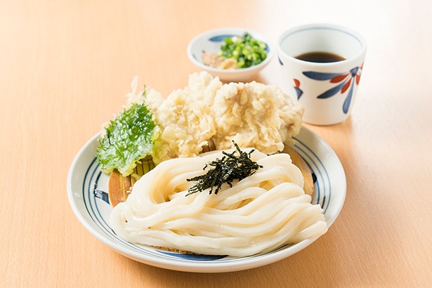 【写真を見る】麺や天ぷらの多彩な食感が楽しめる「とり天ざるうどん」。＋300円のトッピングで注文する場合でも、鶏肉の天ぷらが5個用意される