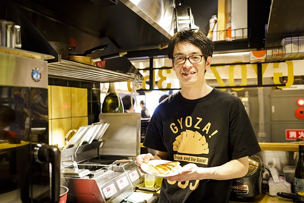 「GYOZA！ 365」のオリジナルTシャツを着た荒木拓善店長。イタリアンシェフと一緒にレシピを製作しているそう