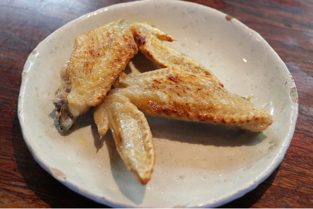 シンプルな味つけが絶妙な手羽先(1本・210円)。かじると脂がジュッと口の中に広がるのでやけどにも注意