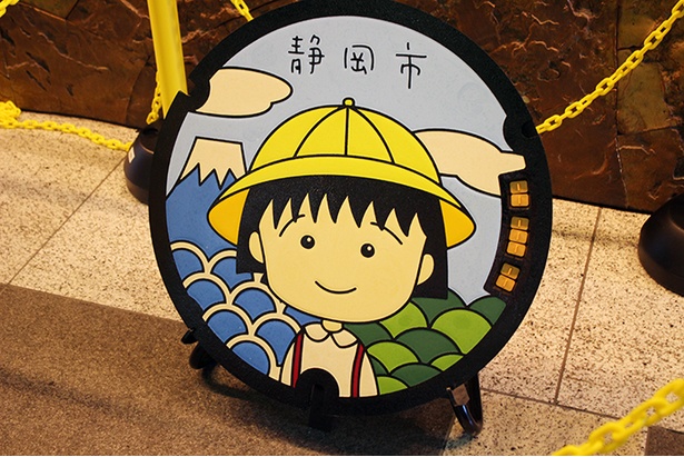 静岡市葵区役所内に展示された黄色い帽子のまるちゃんマンホール