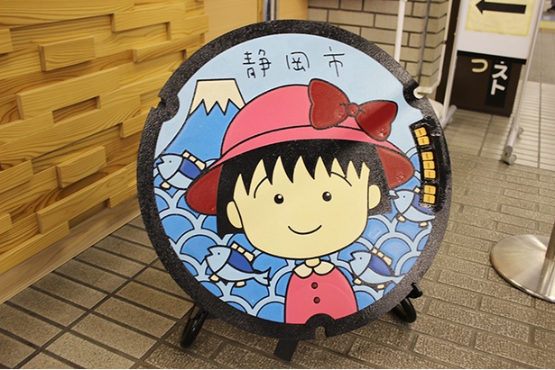 静岡市清水区役所内に展示された赤い帽子のまるちゃんマンホール