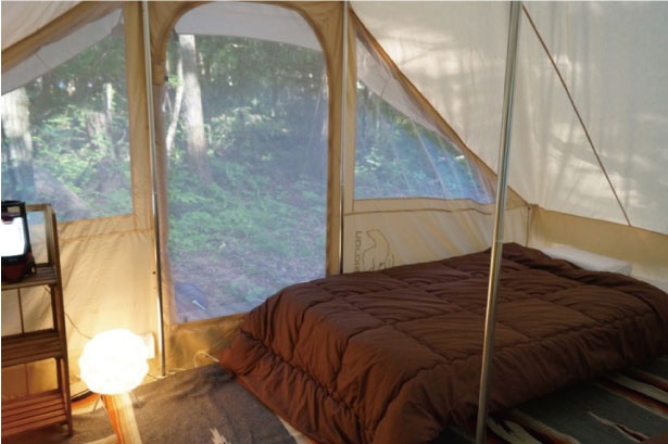 ベッドが設置された、PICA富士吉田のリビングスペース。中からも森の雰囲気を感じることができる