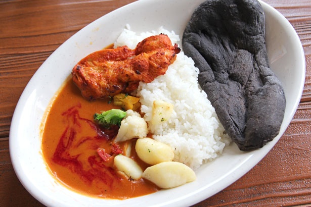ジューシーなタンドリーチキンや野菜をトッピング。ライスに加え、ココアで色を付けた黒いナンも付き、食べごたえ抜群！