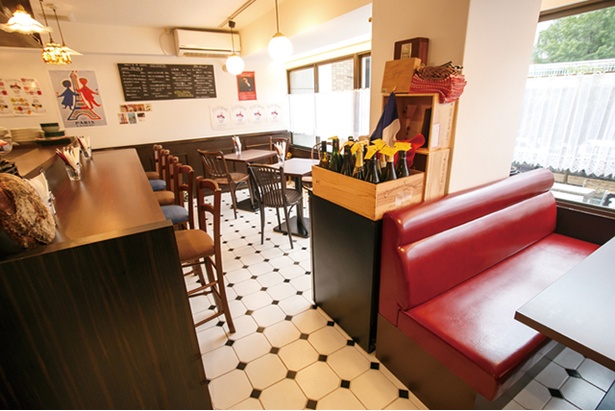 「L’ami」の店内。パリのカフェを思わせるタイル張りの床が印象的で、カウンター、ソファ席もある