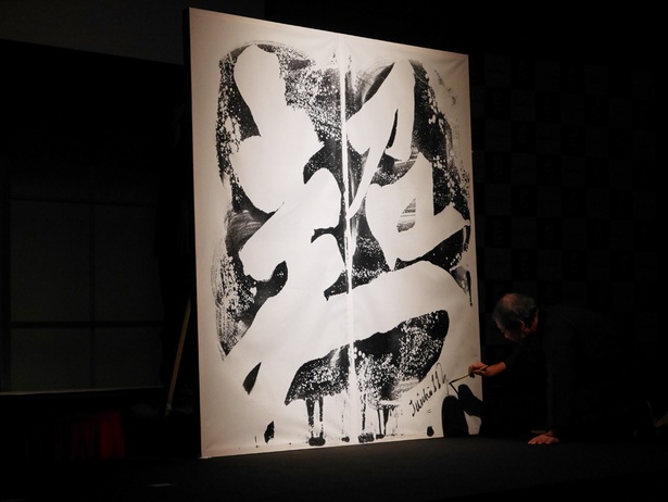 【写真を見る】SYO ARTISTの吉川寿一先生が、今シーズンのテーマである文字『超』を見事に書き上げた