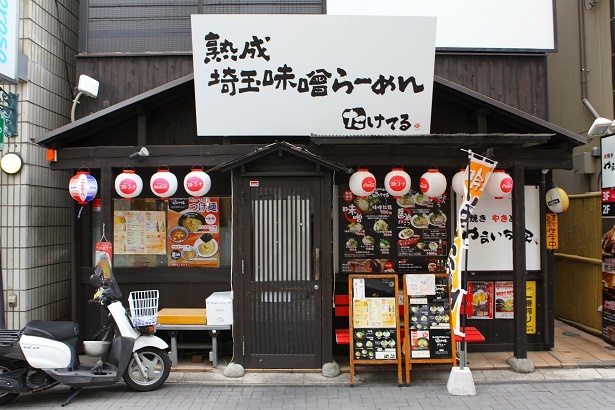 浦和駅西口商店街の中でも目立つ看板。店内にはテーブル席もある「熟成埼玉味噌らーめん　たけてる」