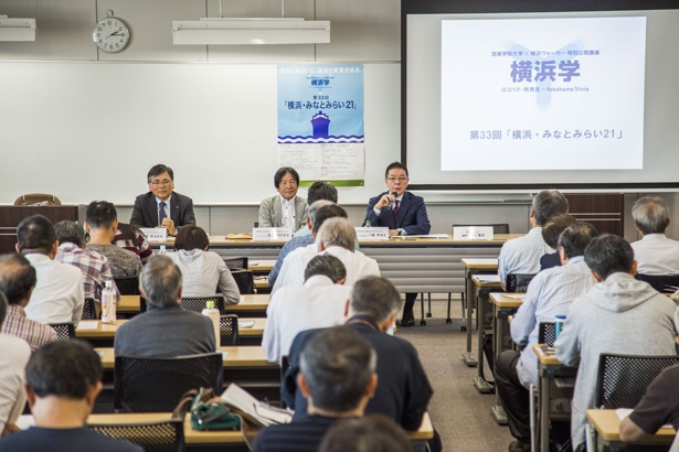【写真を見る】100人近い受講者が集まった会場。ユーモアあふれる講義には、笑いが起こるなごやかな雰囲気の講義になった