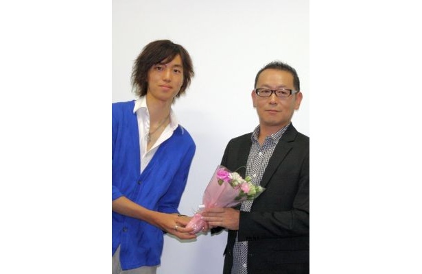 花束を贈呈される土井裕泰監督(右)