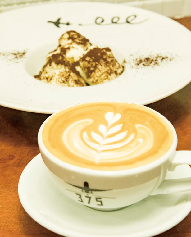 【写真を見る】Cafe Bar 375 / カフェラテ”CLT”(550円)とコーヒーの粉をかけたティラミス”TMS”(500円) 