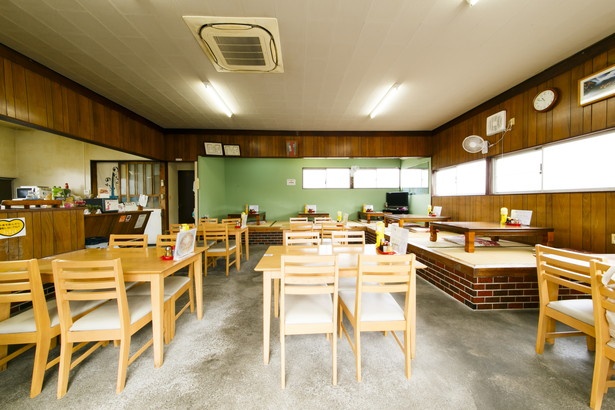 4人がけ卓席が並ぶ広い空間。昭和の食堂のたたずまいを残しつつ清潔感があり、アットホームな雰囲気
