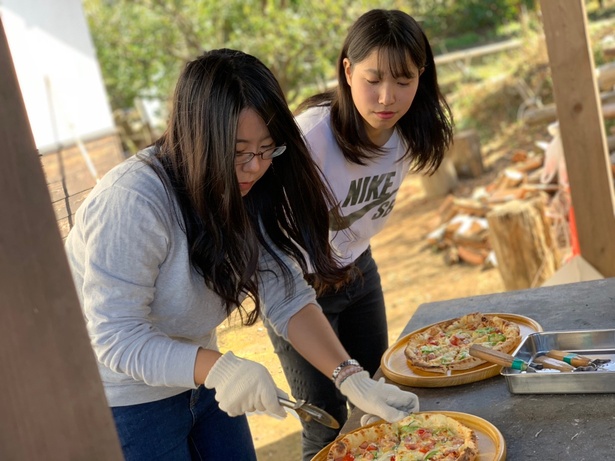 【写真を見る】ピザ窯で焼いたアツアツのピザのおいしさに学生たちも感激！