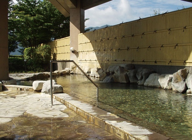 南阿蘇村総合福祉温泉センター ウィナス / 緑の木々に囲まれた露天風呂。湯舟の一角には寝湯も備えている　