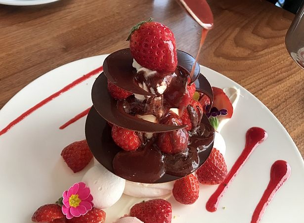温かいいちごソースをかけるとチョコレートディスクが溶けていく！こちらはアフタヌーン スイーツセットなどで食べられるスイーツプレート
