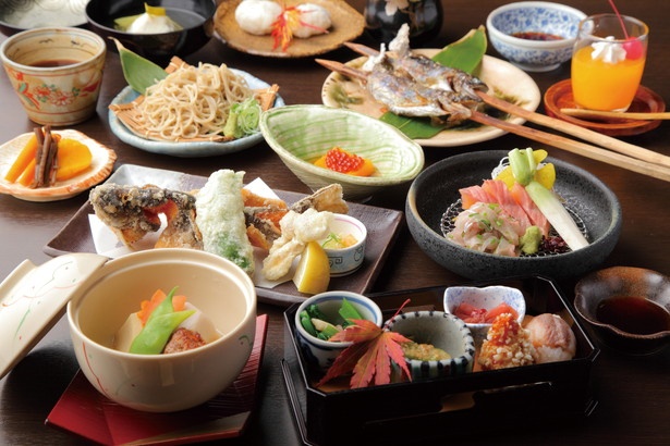 囲炉裏で炙る川魚や野菜、イワナの唐揚げなど全10品が付く奥美濃いろり会席(5700円)。昼食はミニ会席(2800円～)