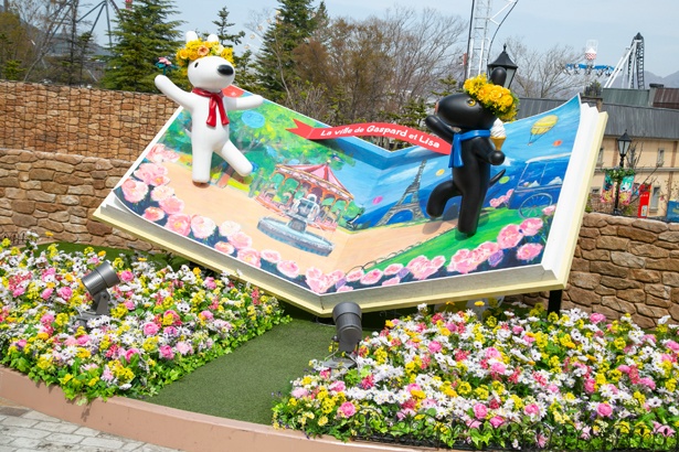 絵本からリサとガスパールが飛び出すフォトスポットの周りを、カラフルな花々が彩る