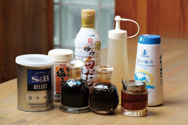 テーブルの上には、酢や唐辛子、ソース、醤油、白だし、塩などが並ぶ