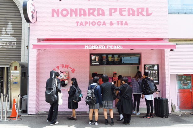 ネコのキャラクター「ノナラくん」がいるポップなピンク色の壁/ノナラパール 心斎橋店