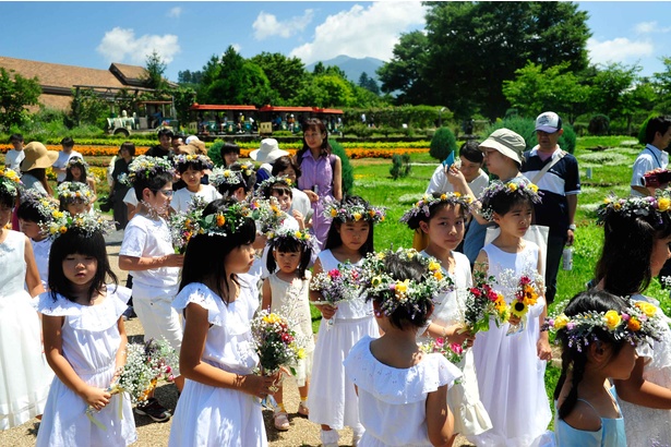 【写真を見る】白い洋服に花冠やブーケで着飾ったかわいらしい子供たちの行進