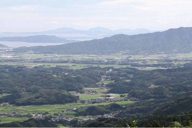【写真を見る】 伊都乃国 白糸ファミリーオートキャンプ場 / 木々の間から糸島市街地が見える
