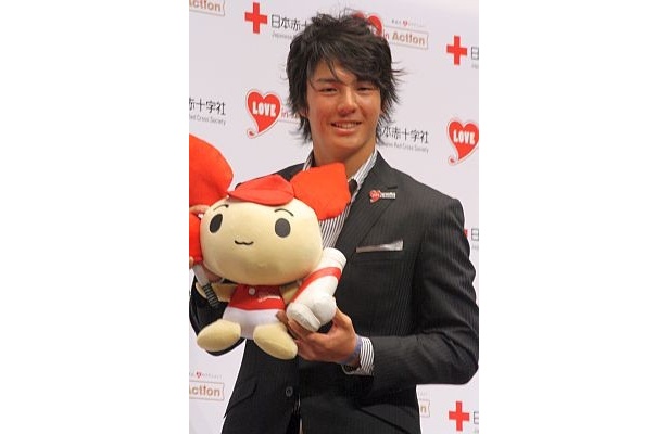 献血推進キャラクター“けんけつちゃん”を持ってニッコリ