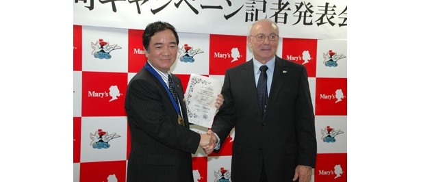 共同キャンペーンのスタートにあたり固い握手を交わす、吉田社長とルッソー村長