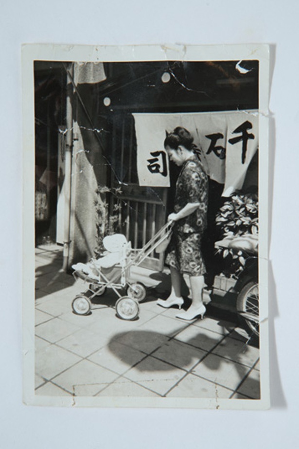 55年前の写真。乳母車に乗った店主の背後には、旧店舗の暖簾が写っている