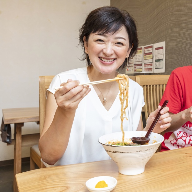 「トマト麺Mami」を試食中。佐藤麻美さんも「おいしい！」と思わず笑顔