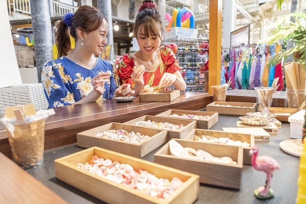 ふたりは写真立ての貝殻探し。「どの貝殻使うの? 私はこのピンクの巻貝をメインにしようかな」、「写真立てに入れる写真、どうしようね。迷っちゃうね」